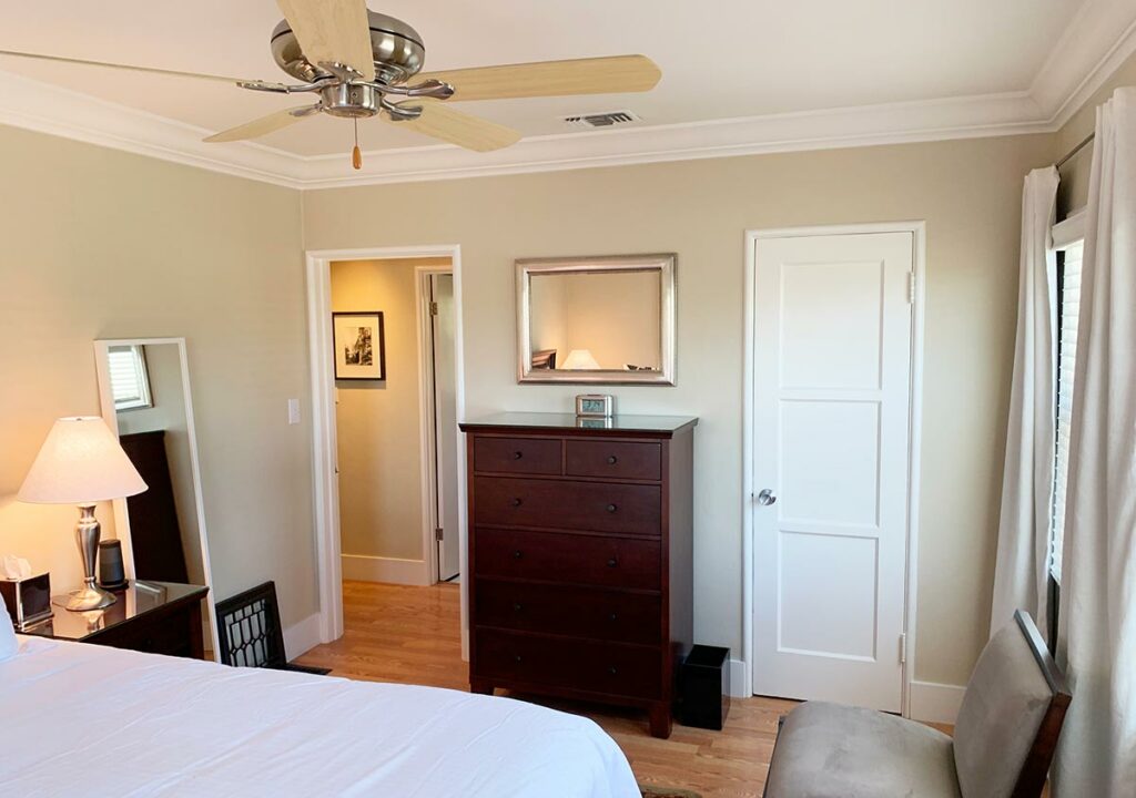 Bed and Breakfast bedroom with dresser, ceiling fan, and closet.