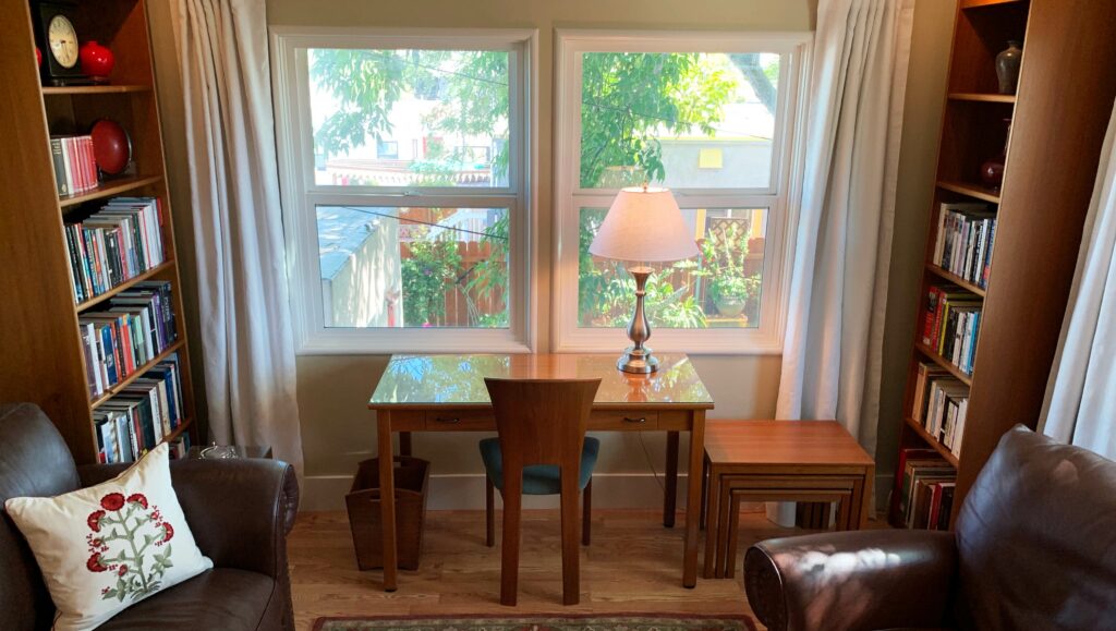 Sun dappled light fills the reading library and working desk in this bed and breakfast