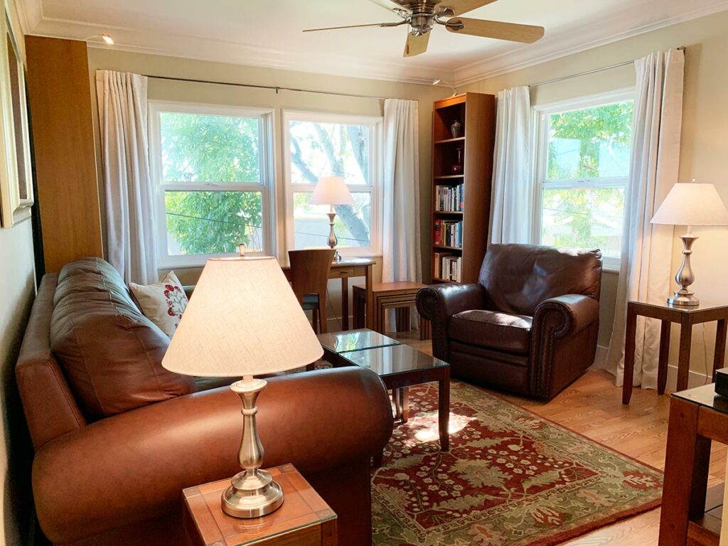 Well appointed living room with comfy leather couch and lounging chair.